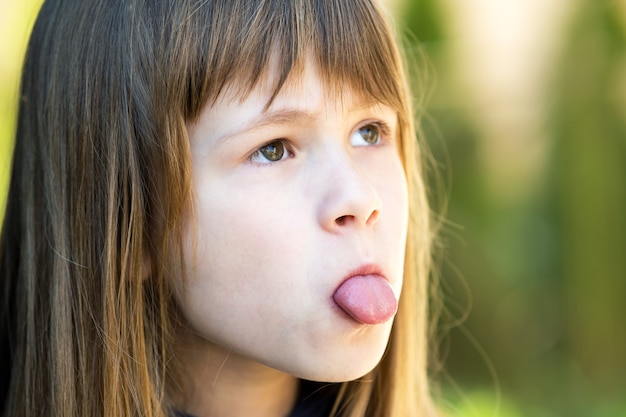 Bouchent le portrait d'une jolie fille montrant la langue.