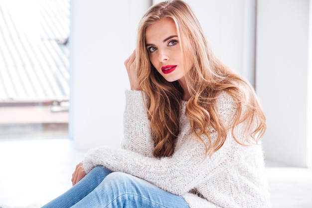 Bouchent le portrait de jolie jeune femme portant chandail et rouge à lèvres à l'avant