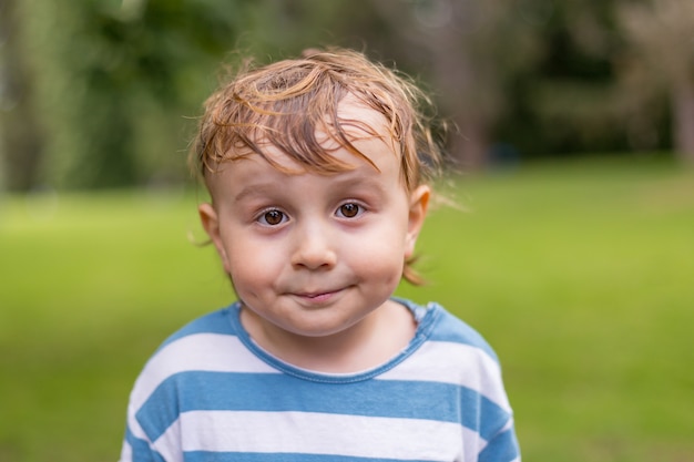 Bouchent le portrait d'un petit garçon souriant dans le parc