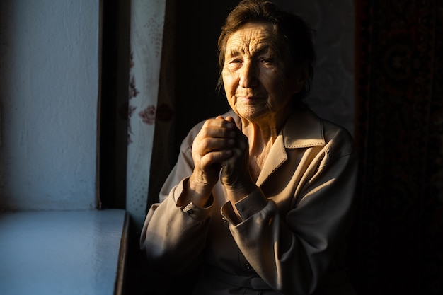 Bouchent le portrait d'une vieille femme en prière