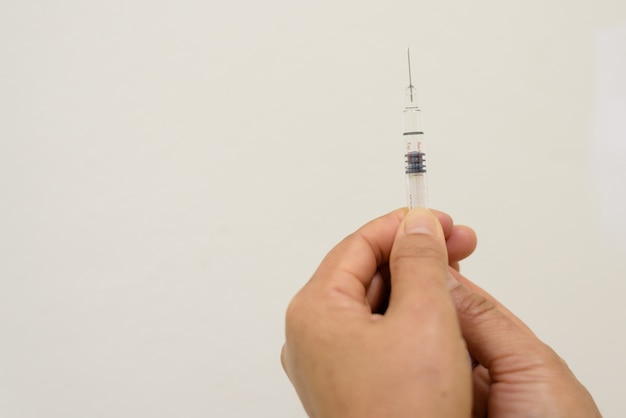 Bouchent la seringue de tenue de main de docteur pour le patient de vaccination