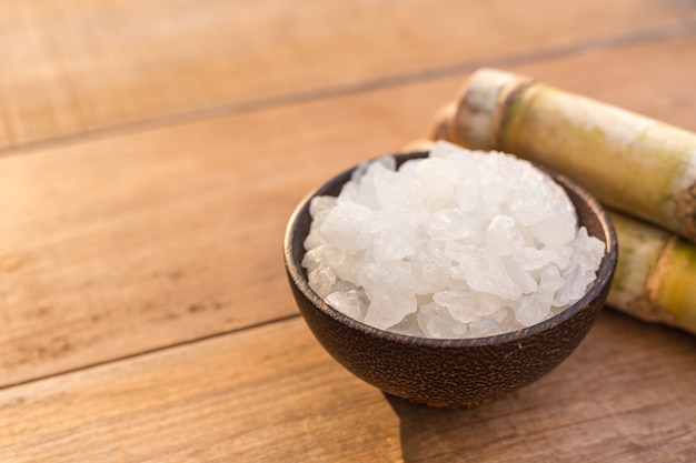 Bouchent le sucre de roche et la canne à sucre sur fond de table en bois