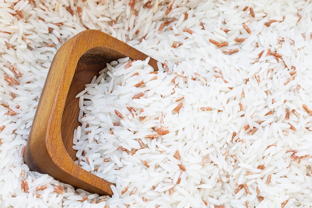 Bouchent la tasse en bois sur mélange de riz blanc avec fond de riz rouge.