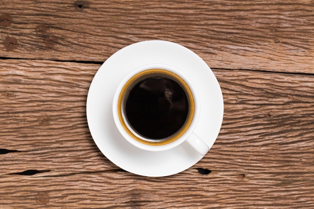 Bouchent une tasse de café sur une surface en bois texturée rugueuse.