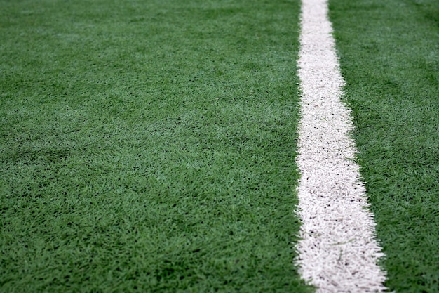 Bouchent la texture du terrain de football avec des rayures blanches, revêtement artificiel vert.