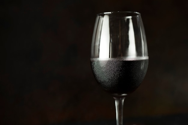 Bouchent le verre de vin rouge frais sur fond noir