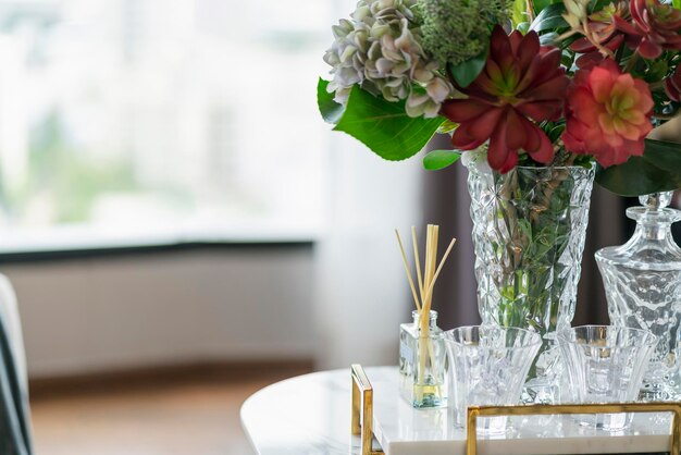 Bouchent la verrerie d'arôme de fleur d'herbe avec ensemble de vase à fleurs décorer des articles sur une table en marbre blanc au concept de design d'intérieur de la maison de la salle de séjour