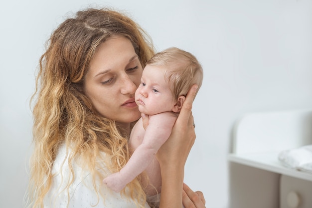 Bouchent les visages de la jeune mère heureuse et du joli bébé nouveau-né.