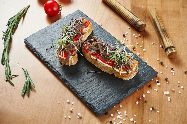 Bouchent la vue délicieuse bruschetta au boeuf et tomates sur la surface en bois