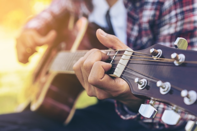 Bouchent la vue du jeune homme jouant de la guitare.