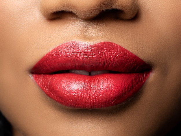 Bouchent la vue des lèvres de la belle femme avec du rouge à lèvres. Maquillage de mode. Cosmétologie, pharmacie ou concept de maquillage de mode.