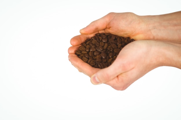 Bouchent la vue des mains montrant les grains de café