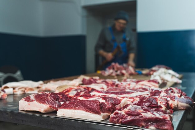 Le boucher coupe du bœuf cru avec un couteau dans l'industrie de la viande de l'abattoir.