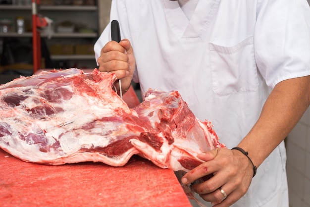 Boucher couper un gros morceau de viande