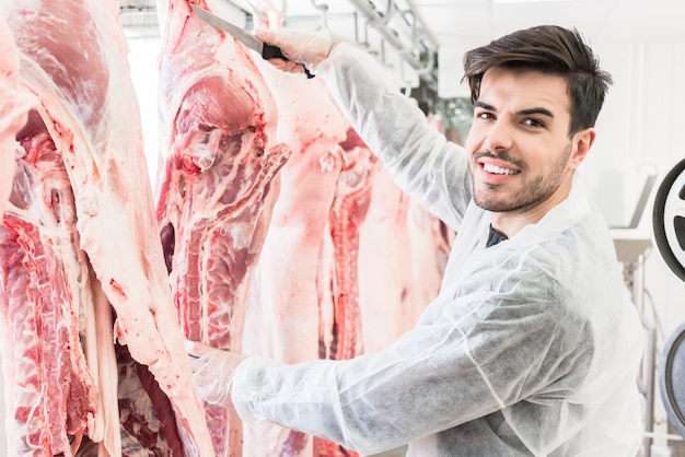 Boucher dans une boucherie ou un abattoir coupant de la viande