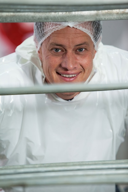 Boucher souriant dans une usine de viande