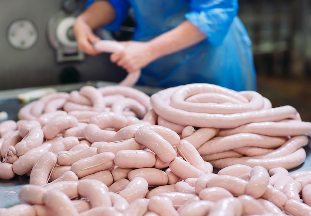 Boucheries préparant des saucisses dans une usine de viande.