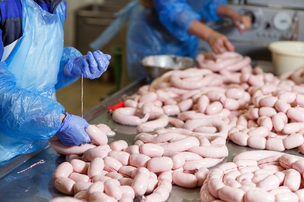 Bouchers transformant des saucisses à une usine de viande.