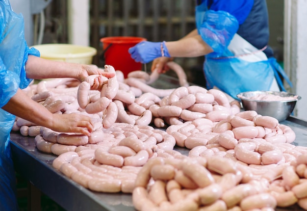 Bouchers transformant des saucisses à une usine de viande.