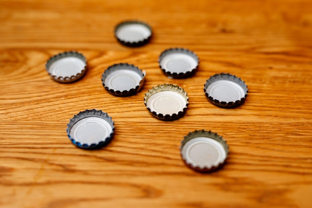 Bouchons de bouteilles de bière sur une table en bois.