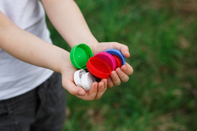 Bouchons de bouteilles en plastique dans les mains des enfants