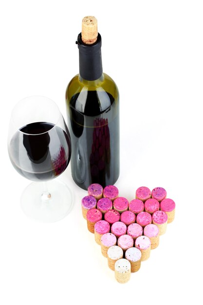 Bouchons de vin disposés en forme de coeur et bouteille de vin isolated on white