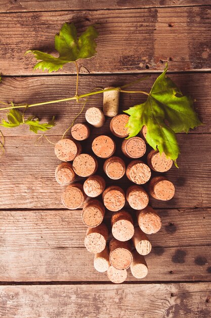 Bouchons de vin sur fond en bois en forme de raisin avec feuille verte