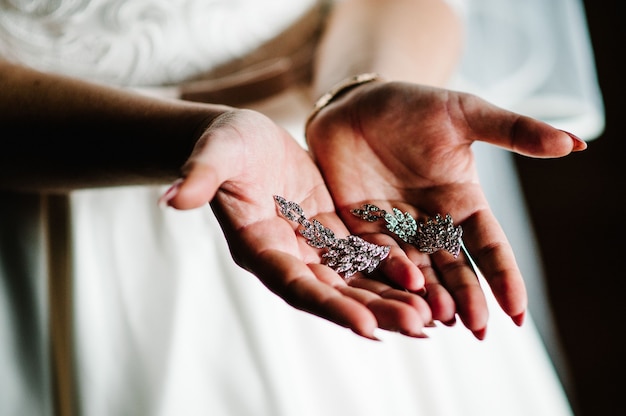 Boucle d'oreille trésors féminins en mains féminines