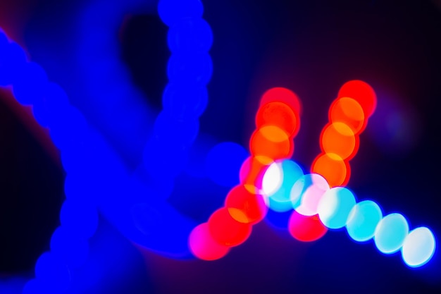 Photo boucles floues néon rouge et bleu de lumières bokeh sur fond abstrait noir des couleurs des années 80