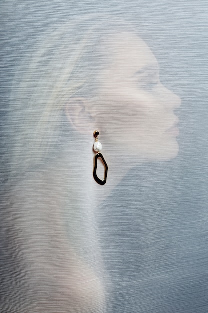 Photo boucles d'oreilles et bijoux à l'oreille d'une femme sexy insérée dans un tissu transparent