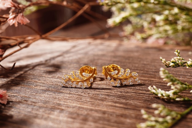 Boucles d'oreilles en or sur fond de bois