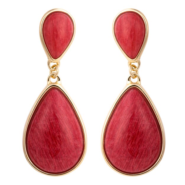 Boucles d'oreilles en or avec pierre précieuse isolé sur une surface blanche