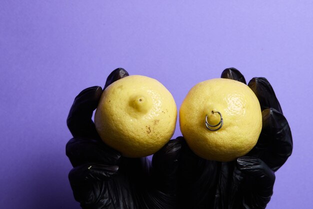 Boucles d'oreilles piercing dans un citron sur fond