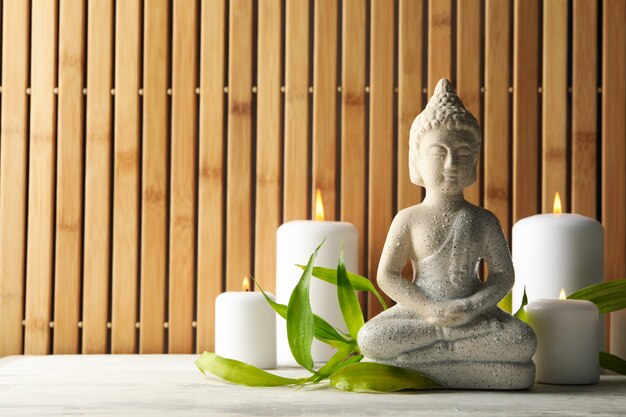 Bouddha et bougies sur table en bois blanc