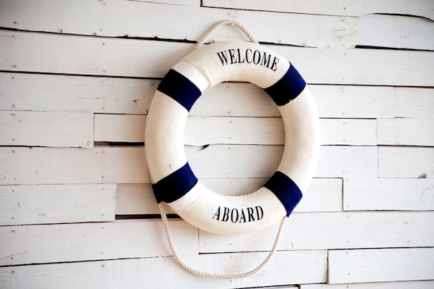 Bouée de sauvetage blanche avec bienvenue à bord sur mur blanc