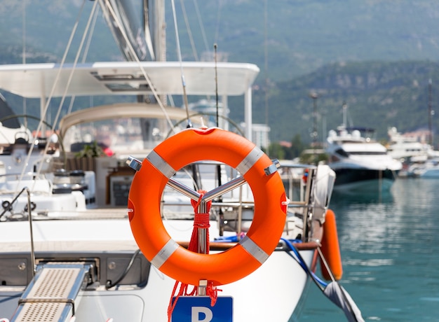 Bouée de sauvetage dans le port de mer contre yacht de luxe