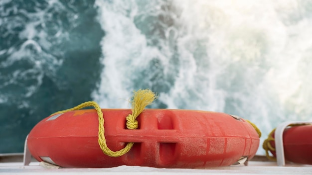 Photo bouée de sauvetage devant le fond de la mer ondulée