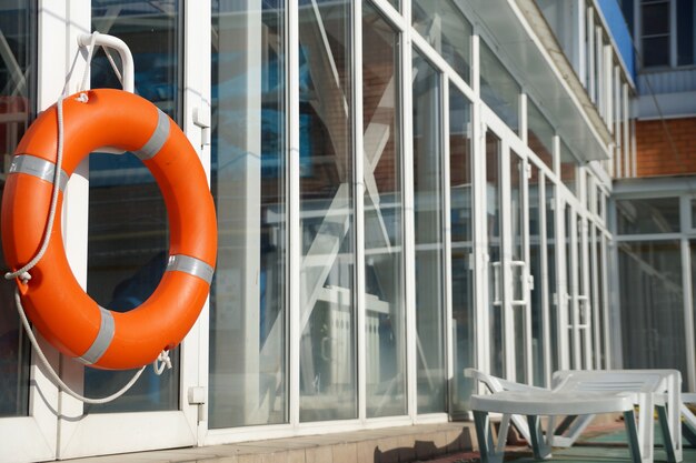 Bouée de sauvetage orange sur un mur d'une protection de la piscine