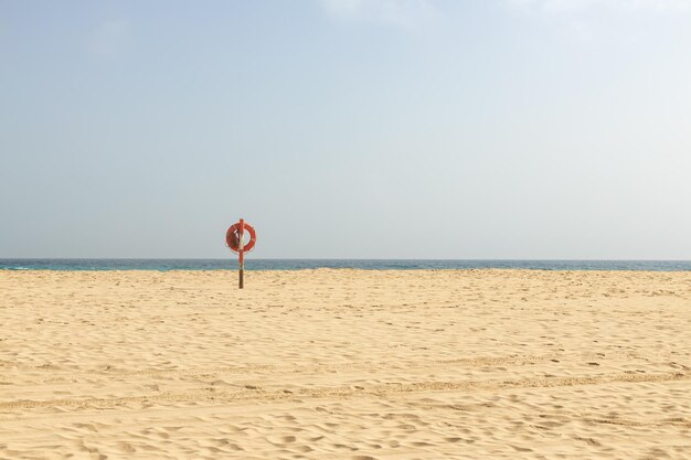 Bouée de sauvetage sur une plage déserte sur ciel bleu