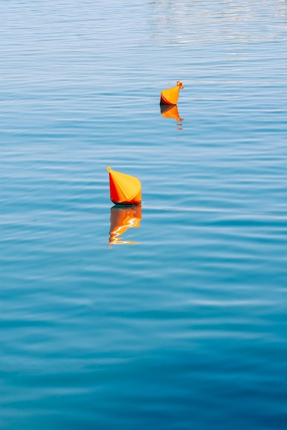 Bouées orange de fond de l'eau sur la surface de l'eau de mer bleue