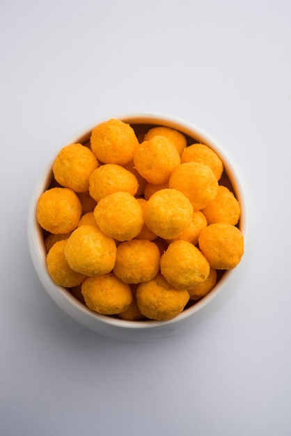 Photo bouffées ou boules aromatisées au fromage en gros plan, servies dans un bol ou sur fond de mauvaise humeur