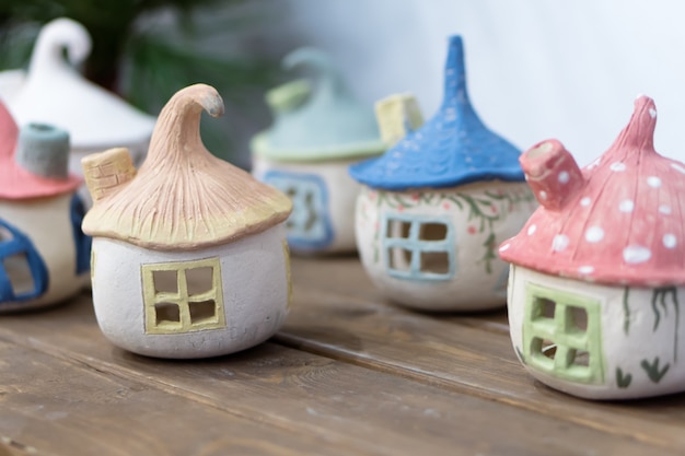 Bougeoirs d'artisanat en céramique de décoration à la maison en forme de maisons d'elfes avec des bougies allumées