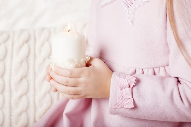 Bougie allumée entre les mains d'une fille.