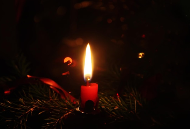 Bougie allumée sur le fond décoré de l'arbre du Nouvel An