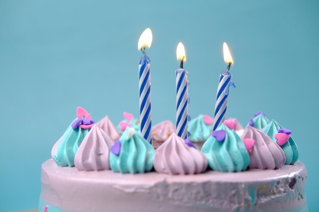 Bougie allumée sur un gâteau d'anniversaire sur un fond de couleur