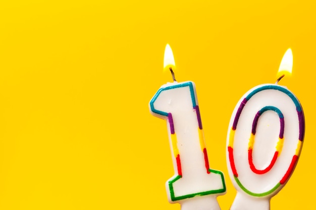 Bougie de célébration d'anniversaire numéro 10 sur un fond jaune vif