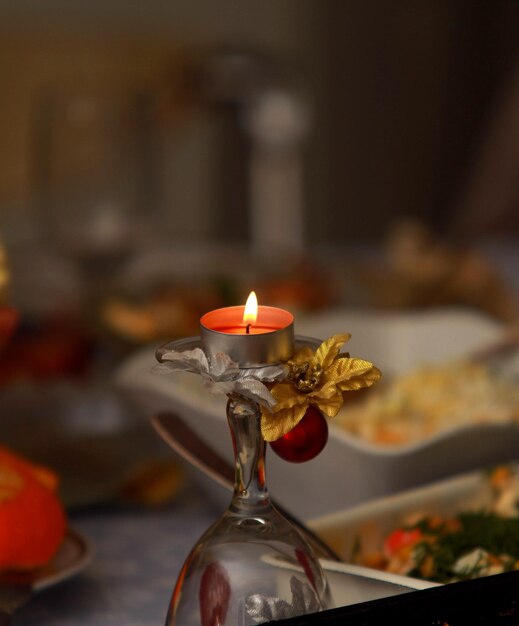 Une bougie dans un verre avec une fleur dessus