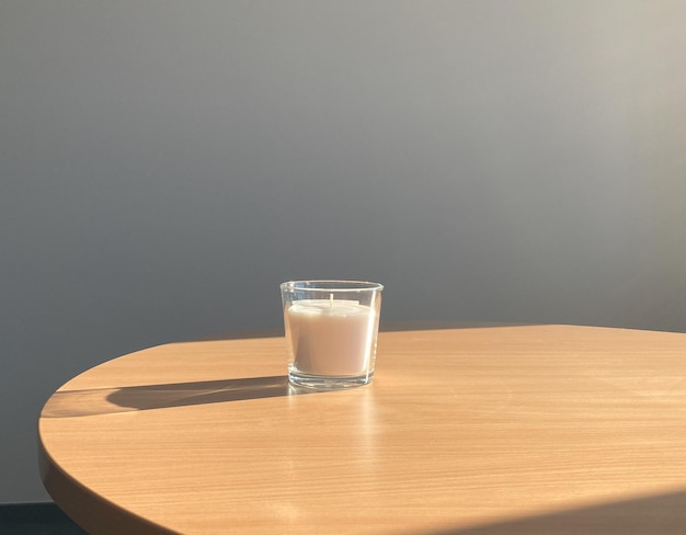 bougie dans le verre sur la table à la lumière du jour