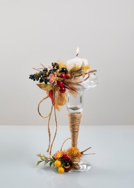 Bougie décorée sur un support en verre et fond blanc