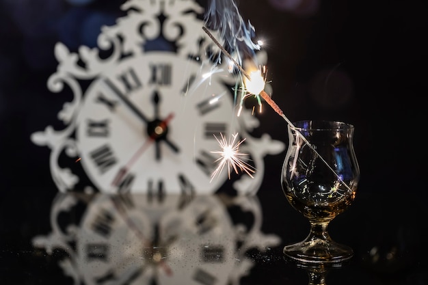 Bougie du Bengale dans un verre contre l'horloge.